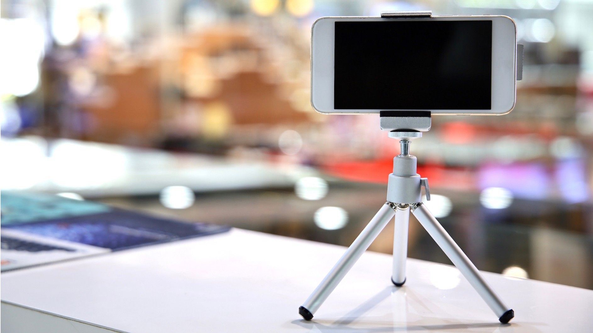 Smartphone on a mini-tripod on a desk with a blurry background